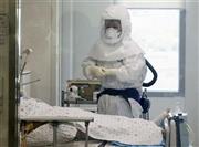 ６月１０日、中東呼吸器症候群（ＭＥＲＳ）コロナウイルスの感染拡大が続くソウル市内の病院の隔離病室で、防護服を着用し業務に当たる医療関係者＝２０１５年、韓国・首都ソウル（聯合＝共同）
