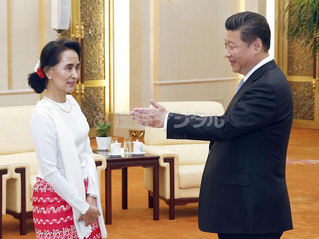 中国の習近平国家主席（右）との会談に向かうミャンマー最大野党、国民民主連盟（ＮＬＤ）党首のアウン・サン・スー・チー氏＝２０１５年６月１１日、中国・首都北京市西城区の人民大会堂（共同）