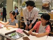 父親の顔を思い浮かべながら父の日のためにパン作りを学ぶ小瀬川夢桜さん（右）＝東京都中央区の三越日本橋本店