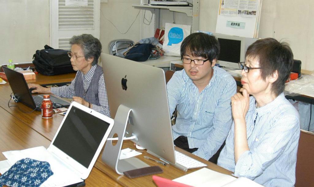 明石舞子団地では大学院生の尾崎斉人さん（中央）がパソコン教室の講師を務める。「分かりやすい」と住民に人気だ＝神戸市