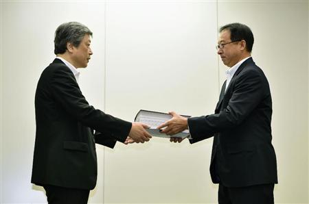 浜岡原発３号機の再稼働を目指し、原子力規制庁の担当者（左）に申請書類を提出する中部電力の増田博武原子力部長＝１６日午前、東京都港区