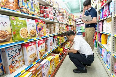 ＭＥＲＳ感染が疑われ、自宅に隔離された人に支給する生活用品を購入する公務員＝１７日、ソウル市内（聯合＝共同）