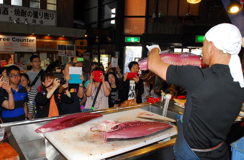 観光客らでにぎわう和歌山市の黒潮市場のマグロ解体ショー。訪日客も多くみられた