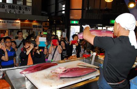 観光客らでにぎわう和歌山市の黒潮市場のマグロ解体ショー。訪日客も多くみられた