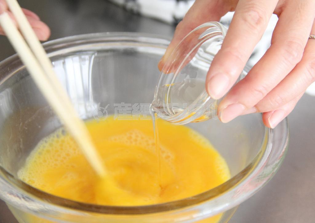 のり入れ卵焼き（作り方１）＿＿卵を割りほぐし、酒、酢、塩を加え混ぜ、もみのり状ののりを加える（田中幸美撮影）