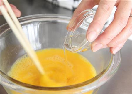 のり入れ卵焼き（作り方１）＿＿卵を割りほぐし、酒、酢、塩を加え混ぜ、もみのり状ののりを加える（田中幸美撮影）