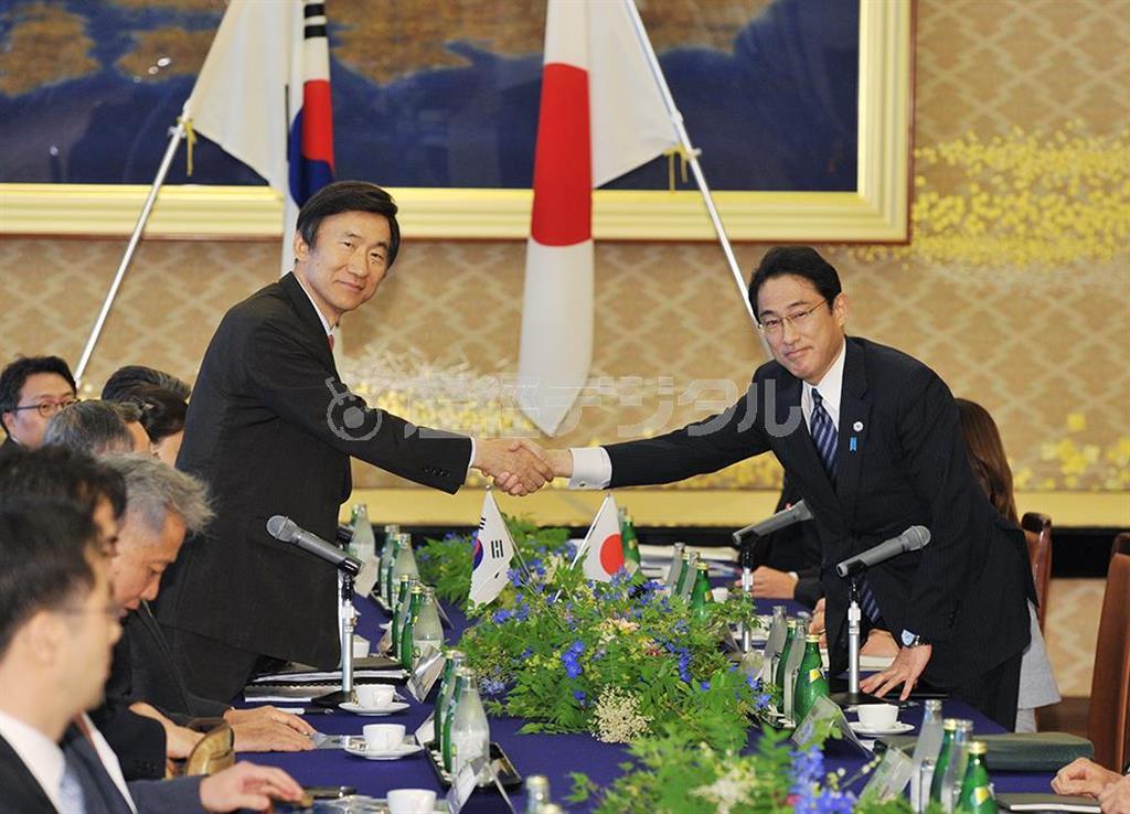 会談を前に握手する岸田文雄外相（右）と韓国の尹炳世（ユン・ビョンセ）外相＝２０１５年６月２１日午後、東京都港区の外務省飯倉公館（代表撮影）