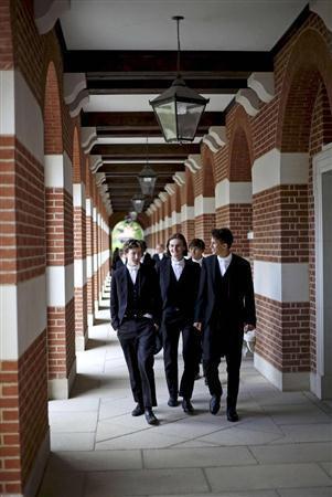 授業の合間にイートン校の構内を歩く生徒たち。黒い燕尾服、チョッキ、ピンストライプのズボンに白いタイは、何世紀も変わることがない伝統の制服で、中国人の多くが憧れている＝２０１５年６月９日、英国・首都ロンドン西郊（ロイター）