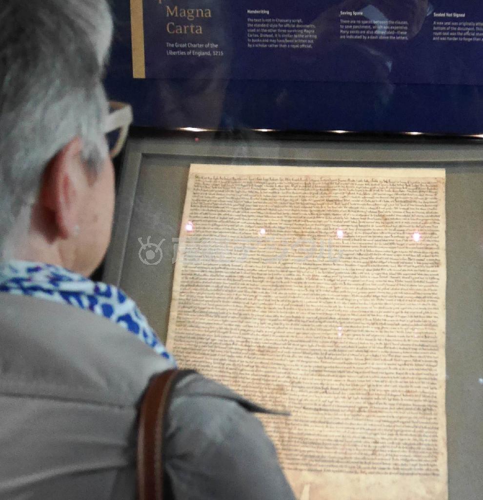ソールズベリー大聖堂のチャプター・ハウスに展示された「マグナ・カルタ」をみる来訪者。現存する４つの原本の中で最も状態がよく保存されているという＝２０１５年６月１５日、英国・ソールズベリー（内藤泰朗撮影）