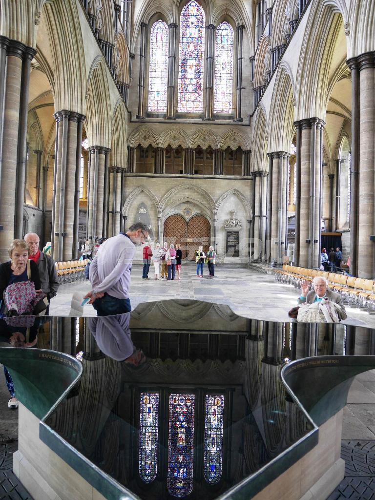 「マグナ・カルタ（大憲章）」の原本が保管されているソールズベリー大聖堂の聖水盤（中央下）をのぞき込む来館者たち。大聖堂は、目を見張る大きさだ＝２０１５年６月１５日、英国・ソールズベリー（内藤泰朗撮影）