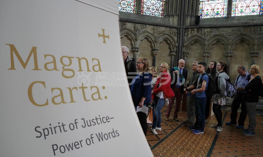 「マグナ・カルタ（大憲章）」を見るために、行列をつくる来訪者。劣化を防ぐために光を遮断した展示コーナーには、「マグナ・カルタ：正義の精神－言葉の力」と書かれていた＝２０１５年６月１５日、英国・ソールズベリー（内藤泰朗撮影）