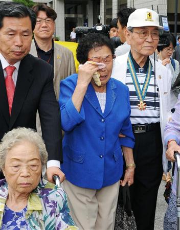 光州高裁で勝訴し、涙ぐんで喜ぶ原告の梁錦徳さん（中央）＝２４日、韓国・光州（共同）