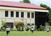 ミャンマーの最大都市ヤンゴンにある日本人学校の新校舎。手前は校庭で遊ぶ幼稚部の児童ら＝２０１５年５月（共同）