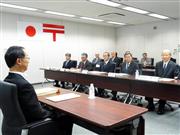 日本郵政の株主総会。西室泰三社長（右から１人目）ら経営陣と、国を代表して財務省の飯塚厚・理財局次長（手前）が出席した＝２６日午前、東京都千代田区霞が関の日本郵政本社（山沢義徳撮影）