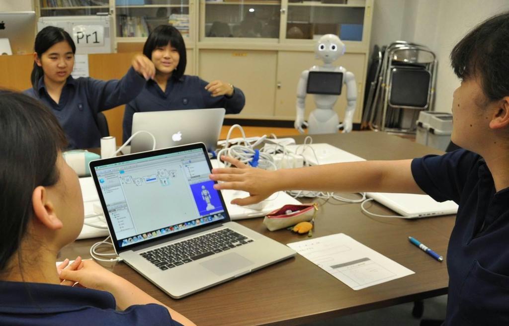 人型ロボット「ペッパー」の腕の動かし方を話し合いながらアプリ開発に取り組む生徒＝１６日、東京都品川区の品川女子学院
