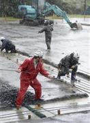 雨が降り続く中で行われる、口永良部（くちのえらぶ）島の住民が入居する仮設住宅の建設作業＝２０１５年６月２８日、鹿児島県熊毛郡屋久島町（共同）