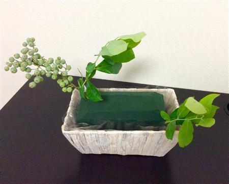 （手順１）オアシスをセットした籠に、ブルーベリーの枝を四隅から外にはみ出るように低めに挿す（花千代さん提供）