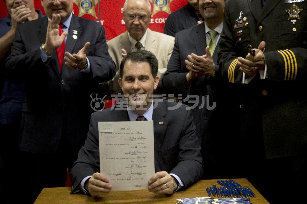 法案に署名し、笑顔を見せるウィスコンシン州のスコット・ウォーカー知事（共和党）。大統領選に挑む現職、元職の州知事たちの強みは、豊富な行政経験と指導力だ＝２０１５年６月２４日、米ウィスコンシン州ミルウォーキー（ＡＰ）