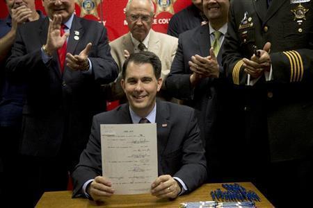 法案に署名し、笑顔を見せるウィスコンシン州のスコット・ウォーカー知事（共和党）。大統領選に挑む現職、元職の州知事たちの強みは、豊富な行政経験と指導力だ＝２０１５年６月２４日、米ウィスコンシン州ミルウォーキー（ＡＰ）