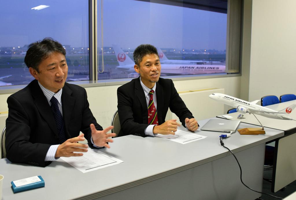 インタビューに笑顔で応じる田嶋雅彦機長（左）と塚本裕司機長＝羽田空港の日本航空テクニカルセンター