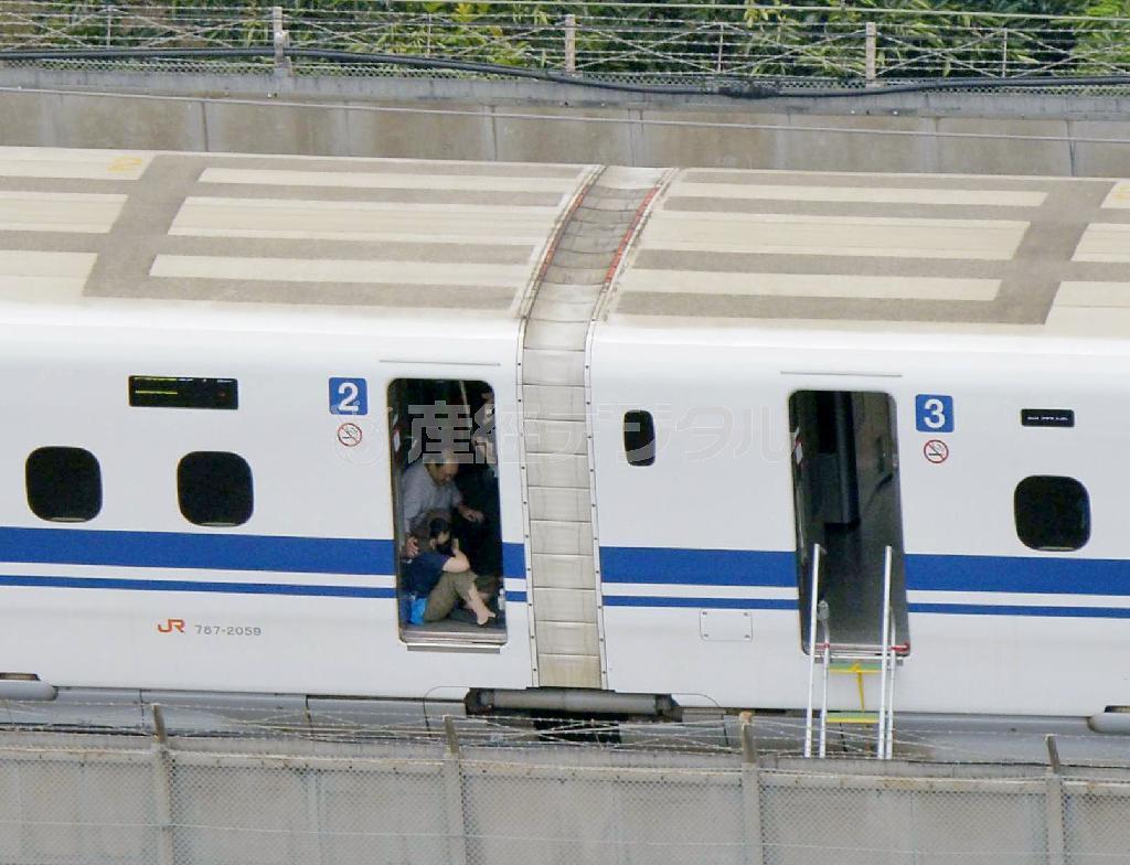 緊急停止した東海道新幹線「のぞみ２２５号」の車内でしゃがみ込む乗客＝３０日午後０時２４分、神奈川県小田原市