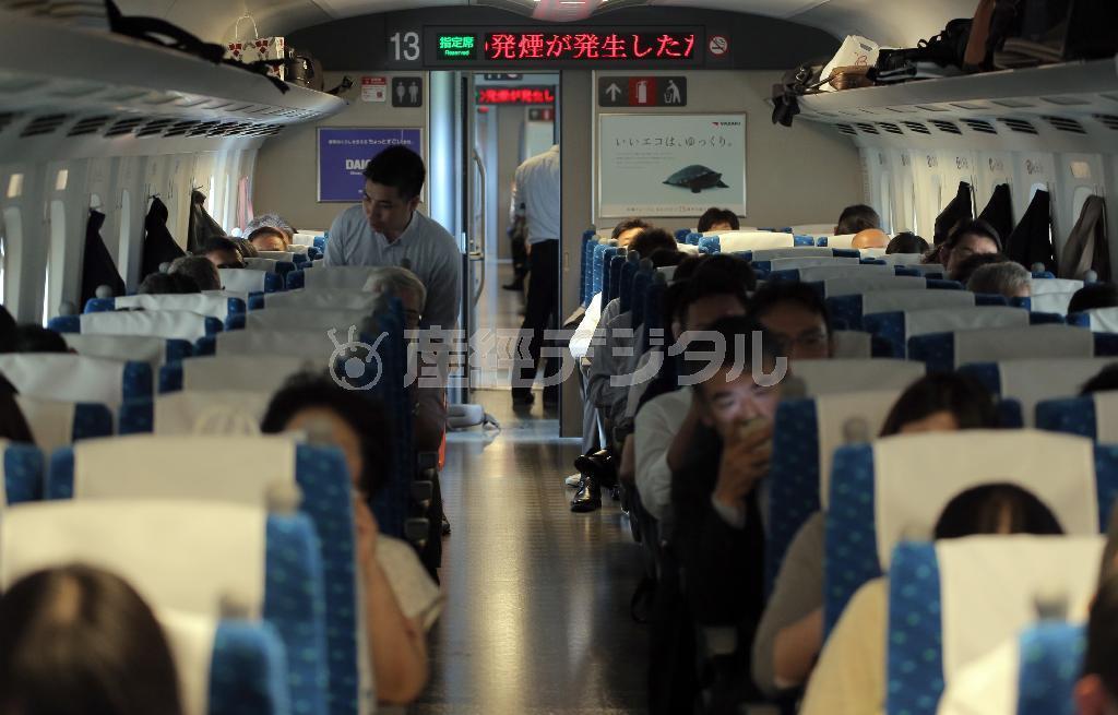 東海道新幹線下り「のぞみ２２５号」の火災で、後続車両も停止。後ろを走っていた「のぞみ２７号」も停車し、停電のため一時空調も止まり、一部トイレも使えない状態に。乗客は運転再開の見込みが無い中、携帯電話で外部と連絡を取るなどしていた＝６月３０日午後０時１２分、神奈川県大磯町（早坂洋祐撮影）