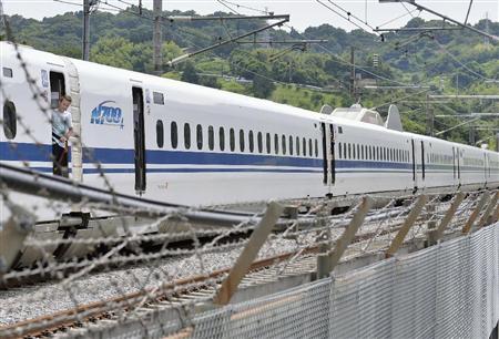 緊急停止した「のぞみ２２５号」のデッキから不安そうに外を見る乗客＝３０日午後１時２３分、神奈川県小田原市