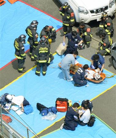 緊急停止した東海道新幹線の車両から搬送され、手当てを受ける人たち＝３０日午後１時２３分、神奈川県小田原市