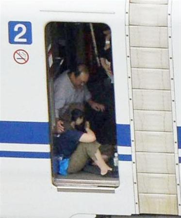 緊急停止した東海道新幹線「のぞみ２２５号」の２号車デッキ付近で座り込む乗客＝３０日午後０時２４分、神奈川県小田原市