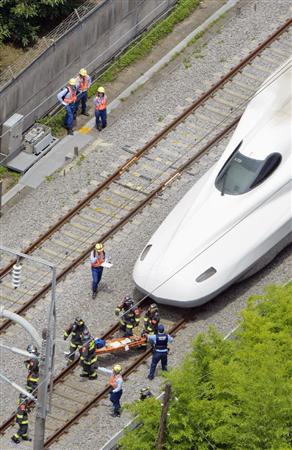 緊急停止した東海道新幹線「のぞみ２２５号」から運び出される乗客＝３０日午後０時３４分、神奈川県小田原市