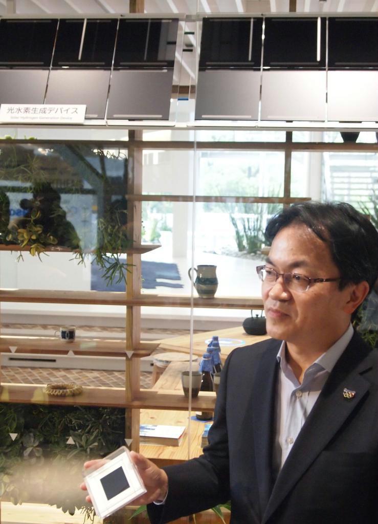 「光水素製造デバイス」の試作機を披露するパナソニックの宮部義幸専務＝３日、東京都江東区