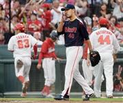 一回、広島・会沢（あいざわ）翼の適時打で田中広輔（左奥）が生還、追加点を許し顔をしかめるヤクルト先発の古野（ふるの）正人（手前）＝２０１５年７月３日、広島県広島市南区・マツダスタジアム（共同）