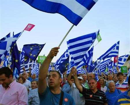 アテネで３日、国民投票での賛成を訴え、ギリシャ国旗やＥＵの旗を振る人々（共同）