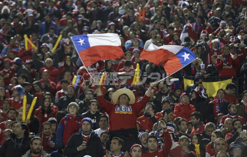 コパ・アメリカの準決勝、チリ対ペルー戦で、国旗を振ってチリ代表を応援するサポーター。地元代表の活躍で、チリ全土は冬の寒さを吹き飛ばす熱気に包まれた＝２０１５年６月２９日、チリ・首都サンティアゴ（ＡＰ）