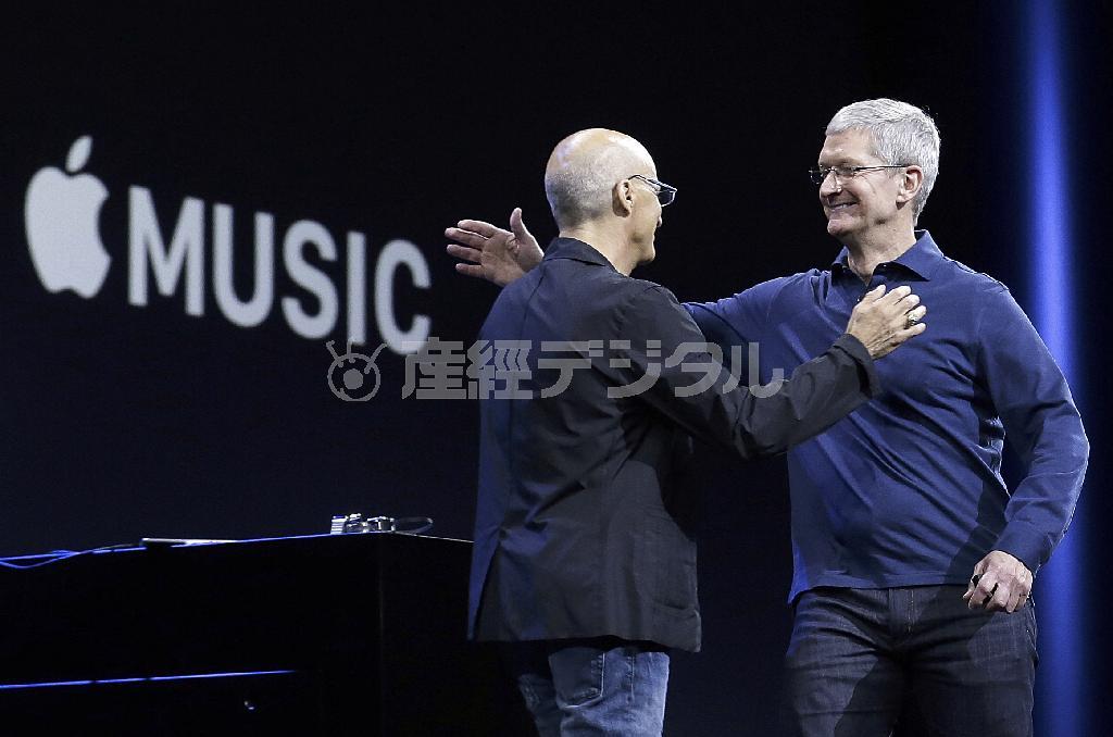 「アップル・ミュージック」の発表会で抱き合うアップルＣＥＯ（最高経営責任者）のティム・クック氏（右）と、ビーツの共同創業者、ジミー・アイオヴィン氏＝２０１５年６月８日、米カリフォルニア州サンフランシスコ（ＡＰ）
