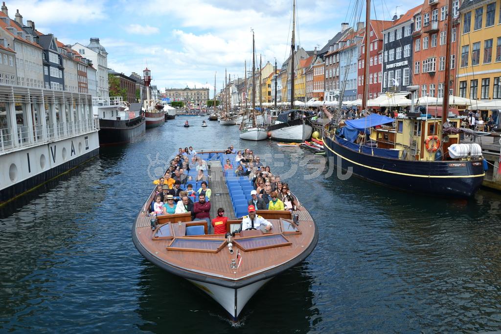 「新港」という意味のニューハウンを出発する運河ツアーのボート。低い橋をくぐれるようにボートは平たい構造になっている＝２０１５年６月２０日、デンマーク・首都コペンハーゲン（銭本隆行さん撮影）