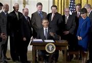 ホワイトハウスで貿易促進権限（ＴＰＡ）法案に署名するバラク・オバマ米大統領（中央）。得意げな表情が「３連勝」の喜びを如実に物語っている＝２０１５年６月２９日、米国・首都ワシントン（ＡＰ）