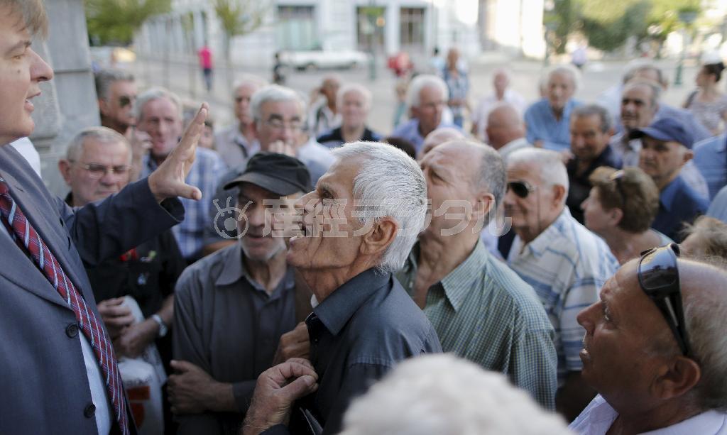 ７月６日、ギリシャの首都アテネの銀行に入ろうとして、行員（左）と言い争いになる年金受給者＝２０１５年（ロイター）