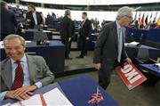 欧州議会の会場で、英国独立党のファラージュ党首（左）からギリシャ語で「反対（ＯＸＩ）」と書かれたプラカードを没収したユンケル欧州委員長＝８日、ストラスブール（ロイター）