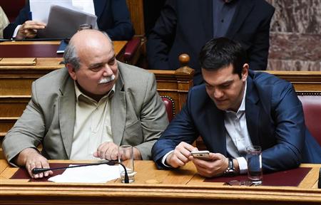 ９日、ギリシャ議会で、ブーチス内務・行政改革相（左）と話すチプラス首相＝アテネ（ＡＰ＝共同）