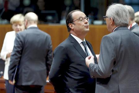 ユーロ圏首脳会議の合間にユンケル欧州委員長（右端）と話し合うフランスのオランド大統領（中央）。左端はドイツのメルケル首相＝１２日、ブリュッセル（ロイター）