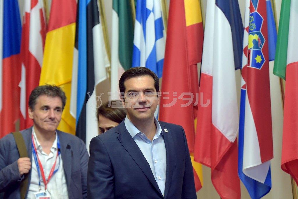 ユークリッド・ツァカロトス財務相（左）とともに会議場を後にするギリシャのアレクシス・チプラス首相。ＥＵ（欧州連合）の支援合意に、表情は柔和だった＝２０１５年７月１３日、ベルギー・首都ブリュッセル（ロイター）