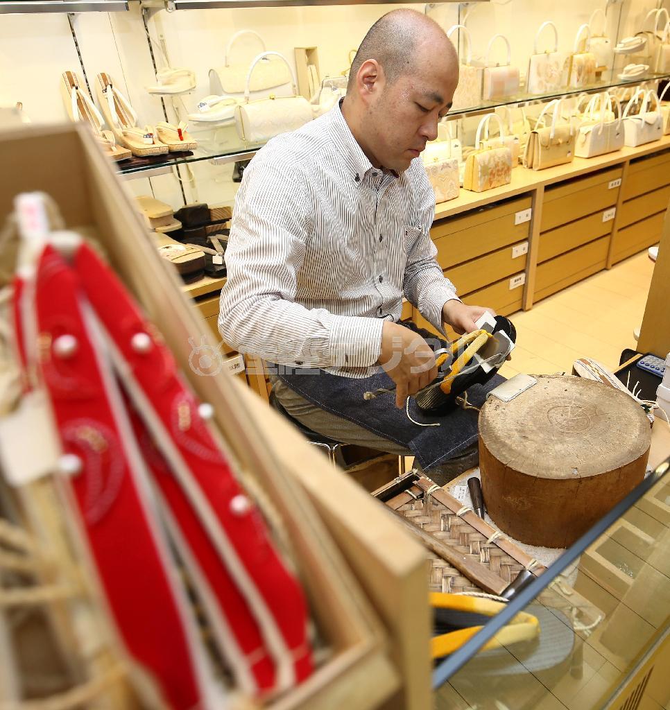 好きな鼻緒を選び、足のサイズに合わせてベテランの職人さんがげた台にすげてくれる＝２０１５年７月２日、東京都中央区銀座（福島範和撮影）