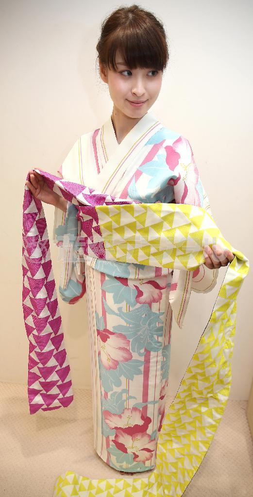 リボン返し（手順１）＿＿帯を前から後ろに胴に２回巻き、左を長めに垂らす＝２０１５年７月２日、東京都中央区銀座（福島範和撮影）