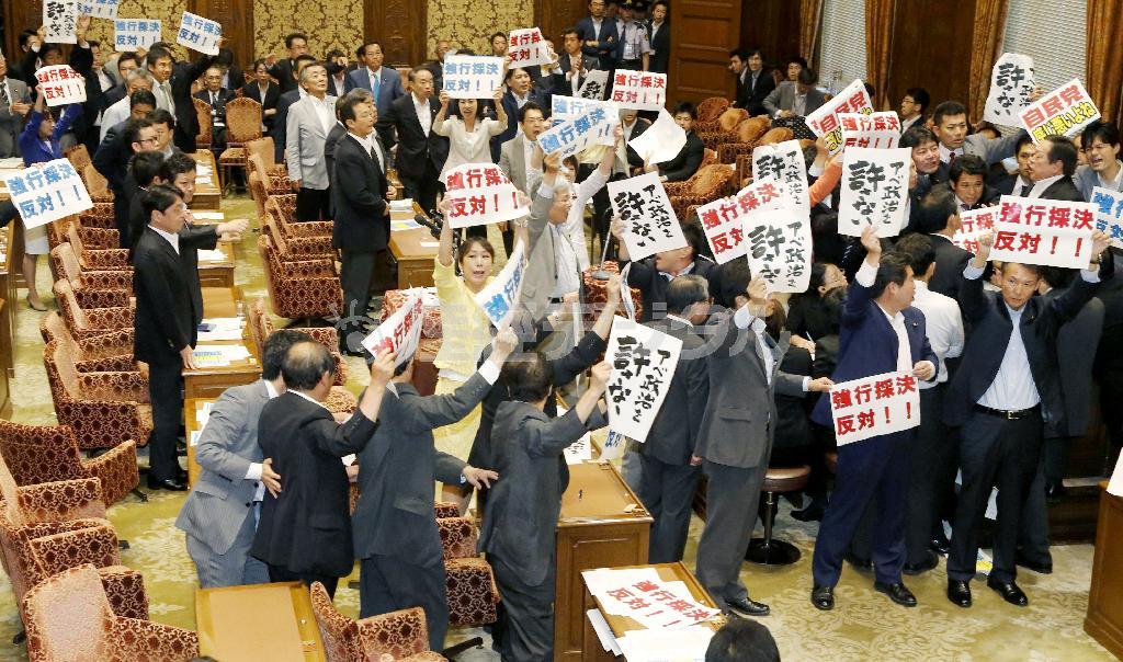 安全保障関連法案を可決した衆院平和安全法制特別委員会。民主党は離席したが議場内でプラカードを掲げるなどして議事進行に抵抗した＝２０１５年７月１５日午後、国会・衆院第１委員室（共同）