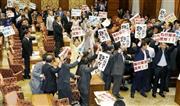 安全保障関連法案を可決した衆院平和安全法制特別委員会。民主党は離席したが議場内でプラカードを掲げるなどして議事進行に抵抗した＝２０１５年７月１５日午後、国会・衆院第１委員室（共同）