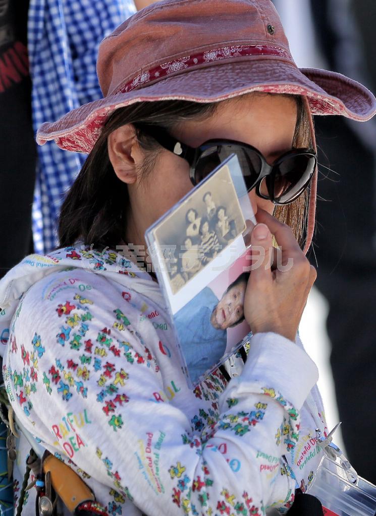 ９年前に亡くなった母・大平利江さんが硫黄島出身だった松岡馨子さん。利江さんの写真を手に、息子と共に初めて母親の故郷を訪れた＝２０１５年６月１５日、東京都小笠原村の硫黄島（早坂洋祐撮影）