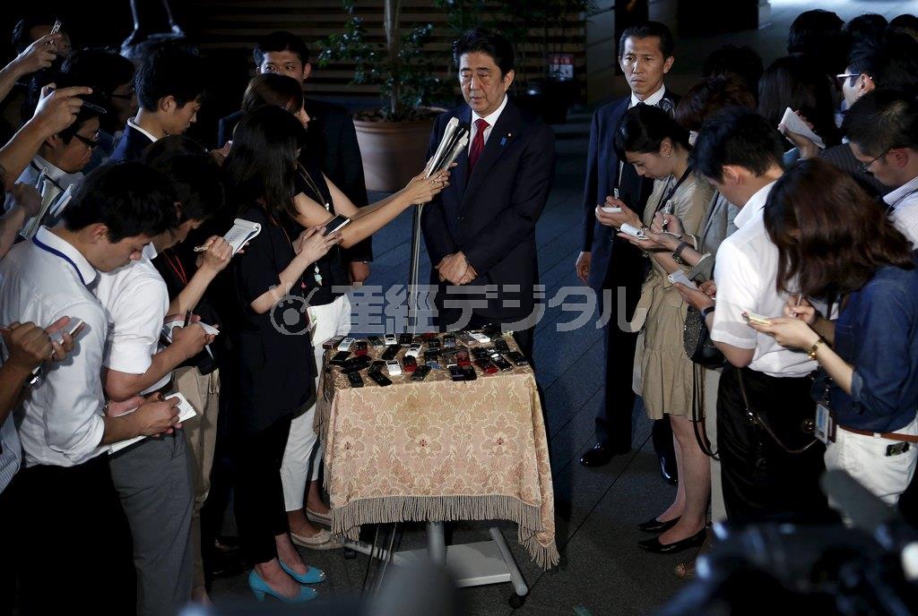 記者団に囲まれ、新国立競技場の建設計画を「白紙に戻す」と表明する安倍晋三（しんぞう）首相（中央）＝２０１５年７月１７日、首相官邸（ロイター）