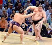 栃煌山（とちおうざん、左）に押し出され、５敗目を喫した逸ノ城（いちのじょう）＝２０１５年７月１９日、愛知県名古屋市中区の愛知県体育館（榎本雅弘撮影）