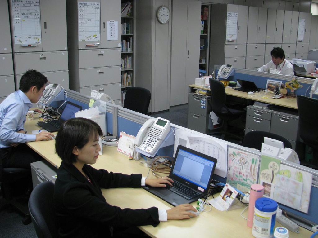 午前８時すぎのオフィスで勤務する木全さん（手前）＝東京都新宿区の損害保険ジャパン日本興亜本社